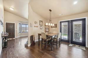 Dining space with dark wood finished floors and lofted ceiling