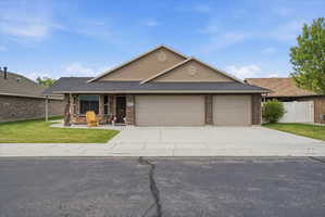 View of front of home featuring a garage, driveway, brick siding, and a shingled roof