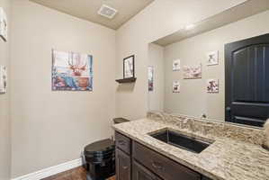 Half bath featuring vanity, dark wood finished floors, and a textured ceiling