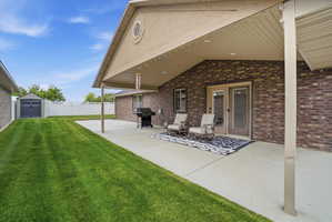 View of patio / terrace featuring a grill and a storage unit