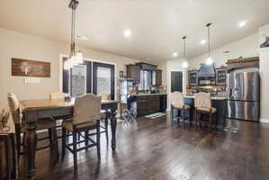 Dining room featuring lofted ceiling, dark wood finished floors, and recessed lighting