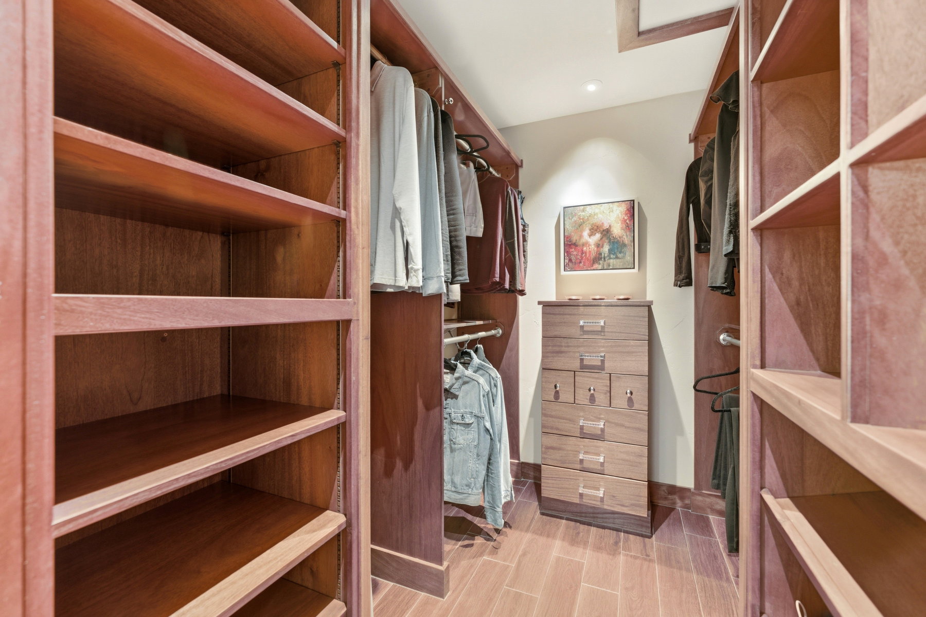 Walk in closet with wood finish floors