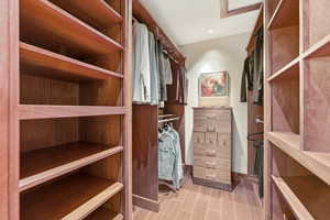 Walk in closet with wood finish floors