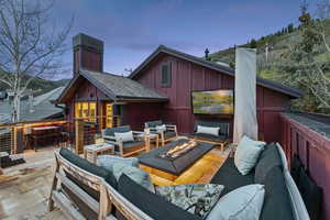 Wooden terrace featuring an outdoor living space with a fire pit and a patio area