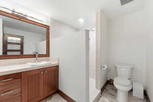 Bathroom with vanity, walk in shower, and light marble finish flooring