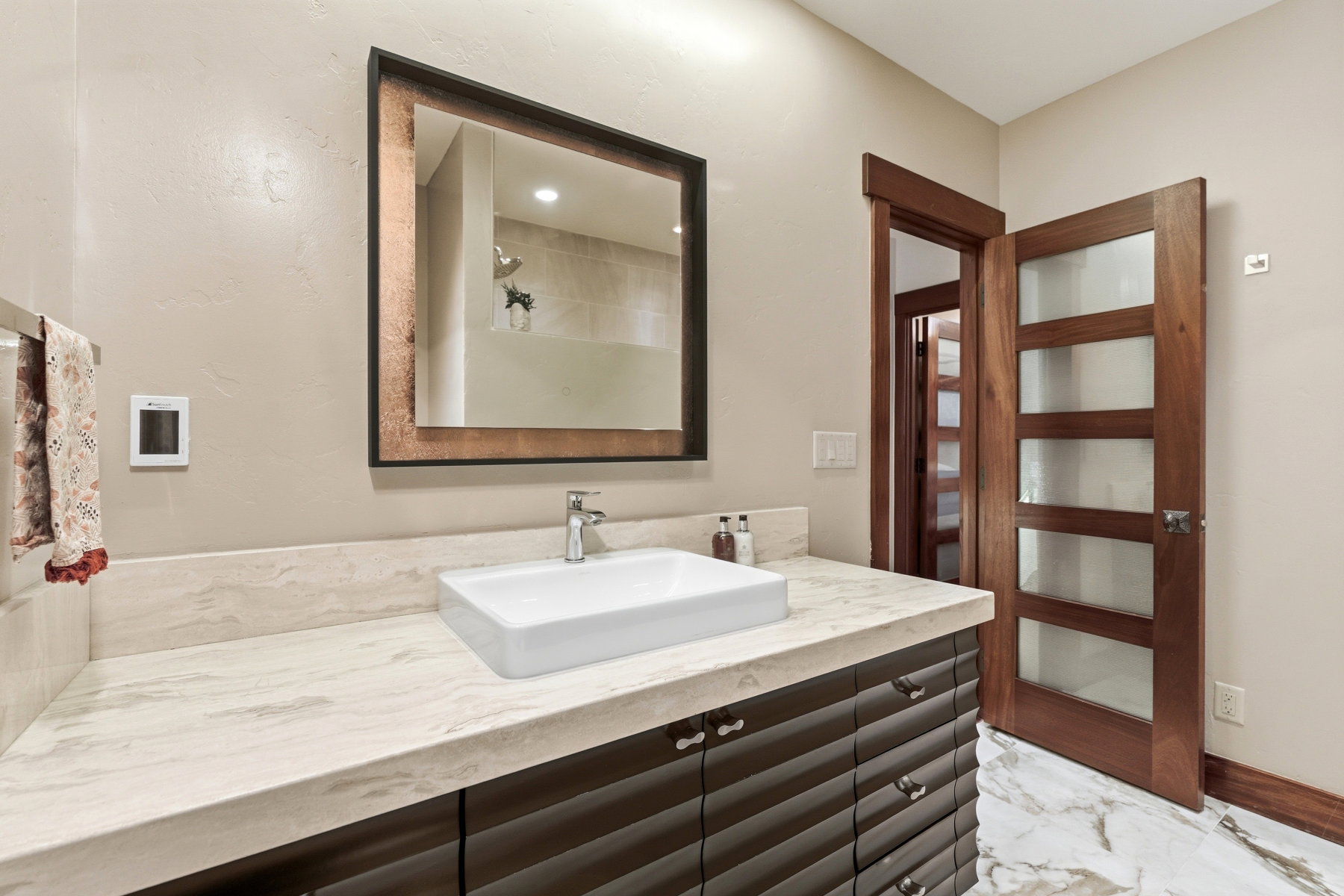 Bathroom featuring vanity, a shower, and light marble finish floors