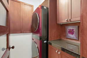 Laundry room with cabinet space and stacked washing machine and dryer