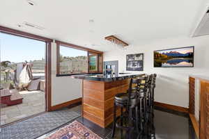 Indoor dry bar with dark countertops