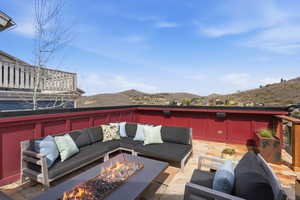 View of patio with an outdoor living space with a fire pit and a mountain view