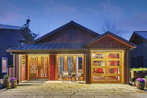 Property entrance with board and batten siding, a standing seam roof, and covered porch