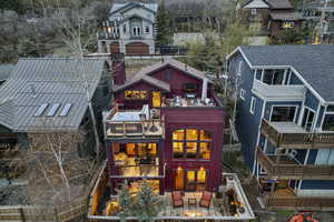 Back of house featuring a balcony, a fenced backyard, a patio, and outdoor furniture