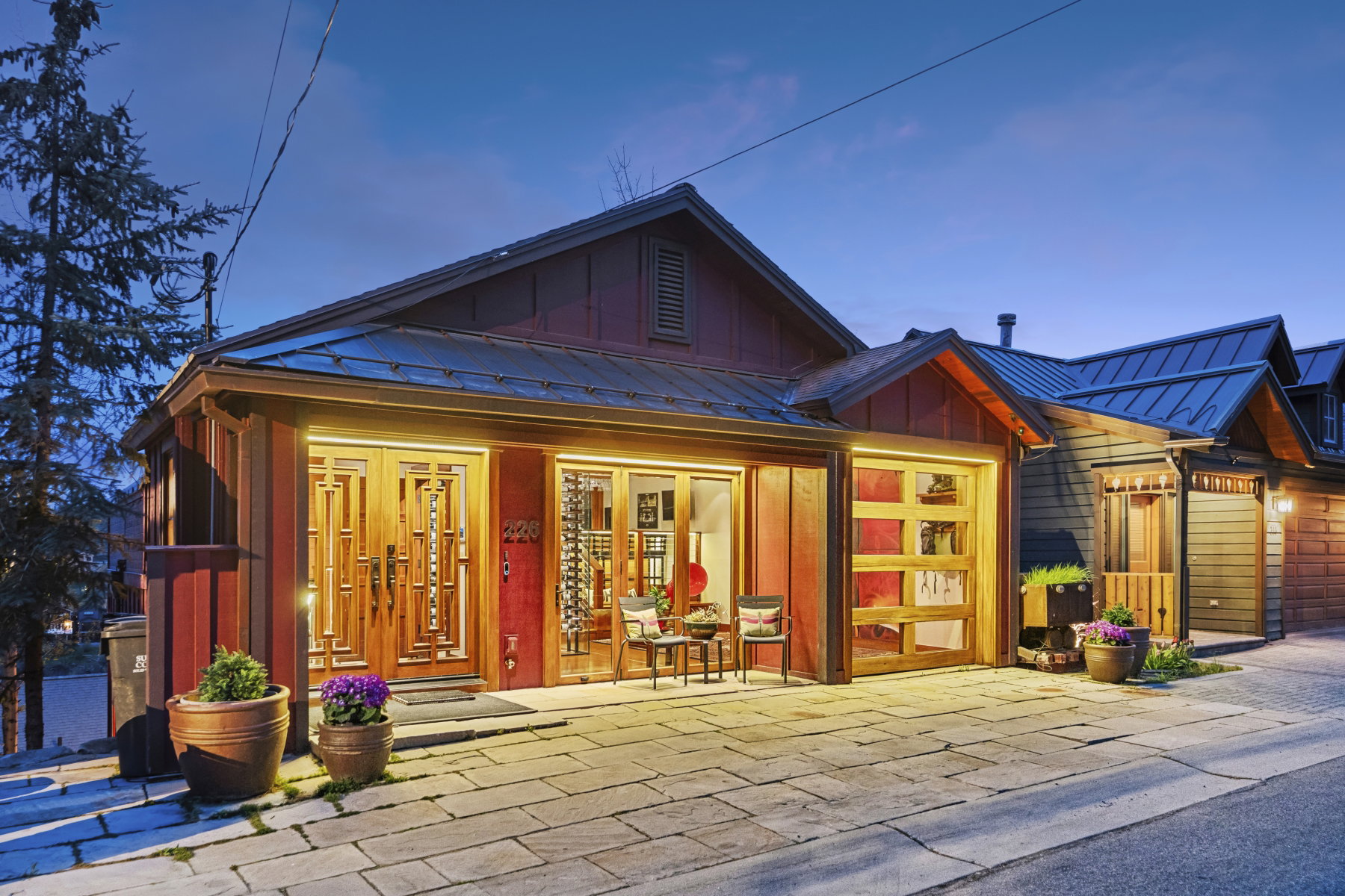 View of front of property featuring board and batten siding, a standing seam roof, a porch, an attached garage, and driveway