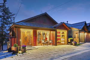 View of front of property featuring board and batten siding, a standing seam roof, a porch, an attached garage, and driveway