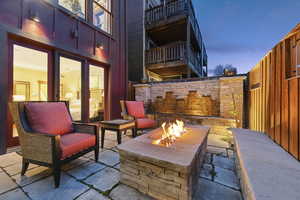Patio terrace at dusk with a fenced backyard, a patio, and an outdoor fire pit