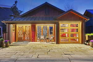 Entrance to property with a standing seam roof, covered porch, and board and batten siding