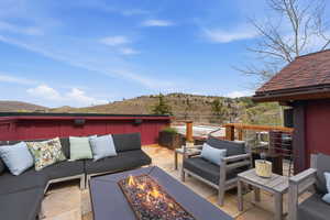 View of patio featuring an outdoor living space with a fire pit and a mountain view