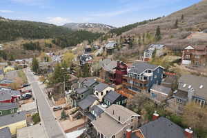 Aerial view of property's location with a mountainous background and a forest