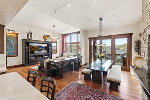 Dining space with wood finished floors, plenty of natural light, and track lighting