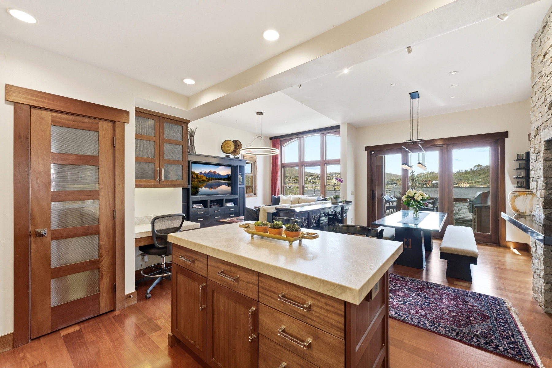 Kitchen featuring wood finish cabinets, light countertops, light wood finished floors, a center island, and pendant lighting