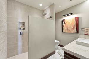 Full bathroom featuring a walk in shower, vanity, and recessed lighting