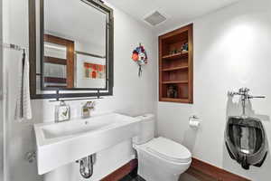 Half bath featuring toilet and built in shelves