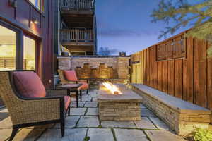 Patio terrace at dusk featuring a patio area, an outdoor fire pit, and a fenced backyard