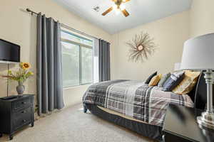 Bedroom with light colored carpet and a ceiling fan