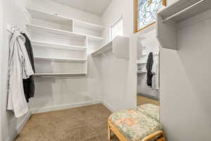 Walk in closet featuring light colored carpet