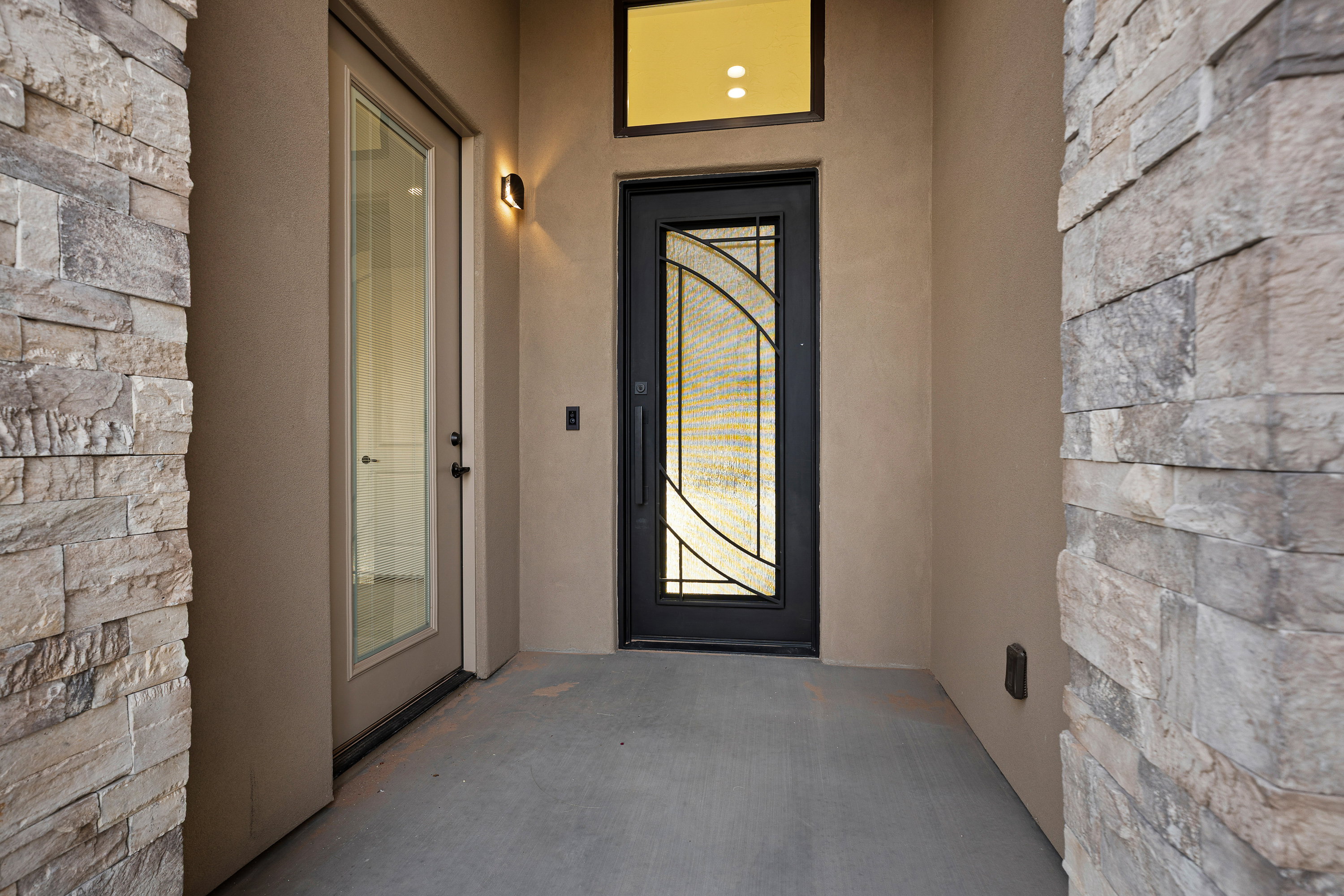 View of exterior entry with stucco siding and a patio