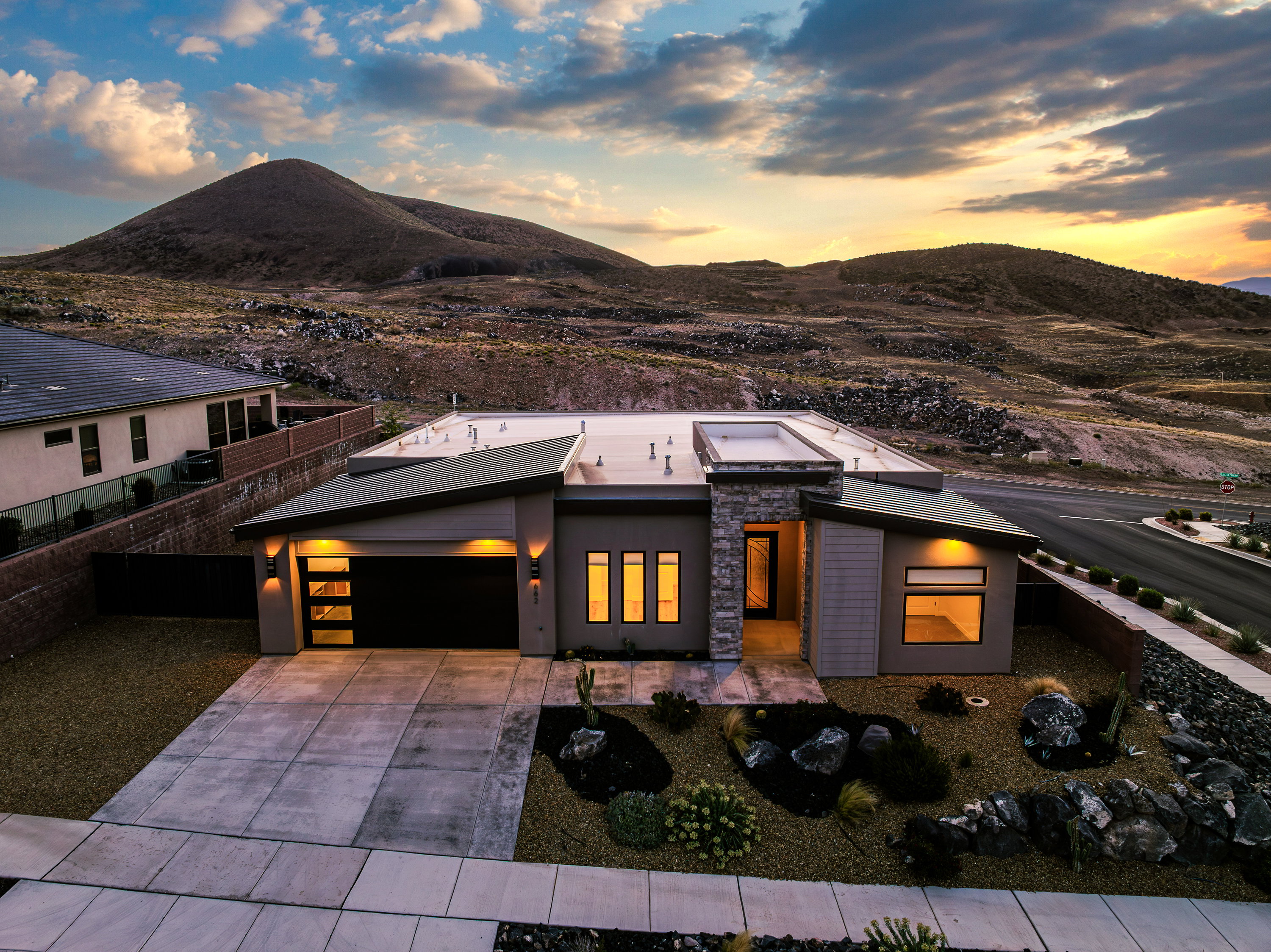 Modern home featuring a mountain view, an attached garage, driveway, and stucco siding
