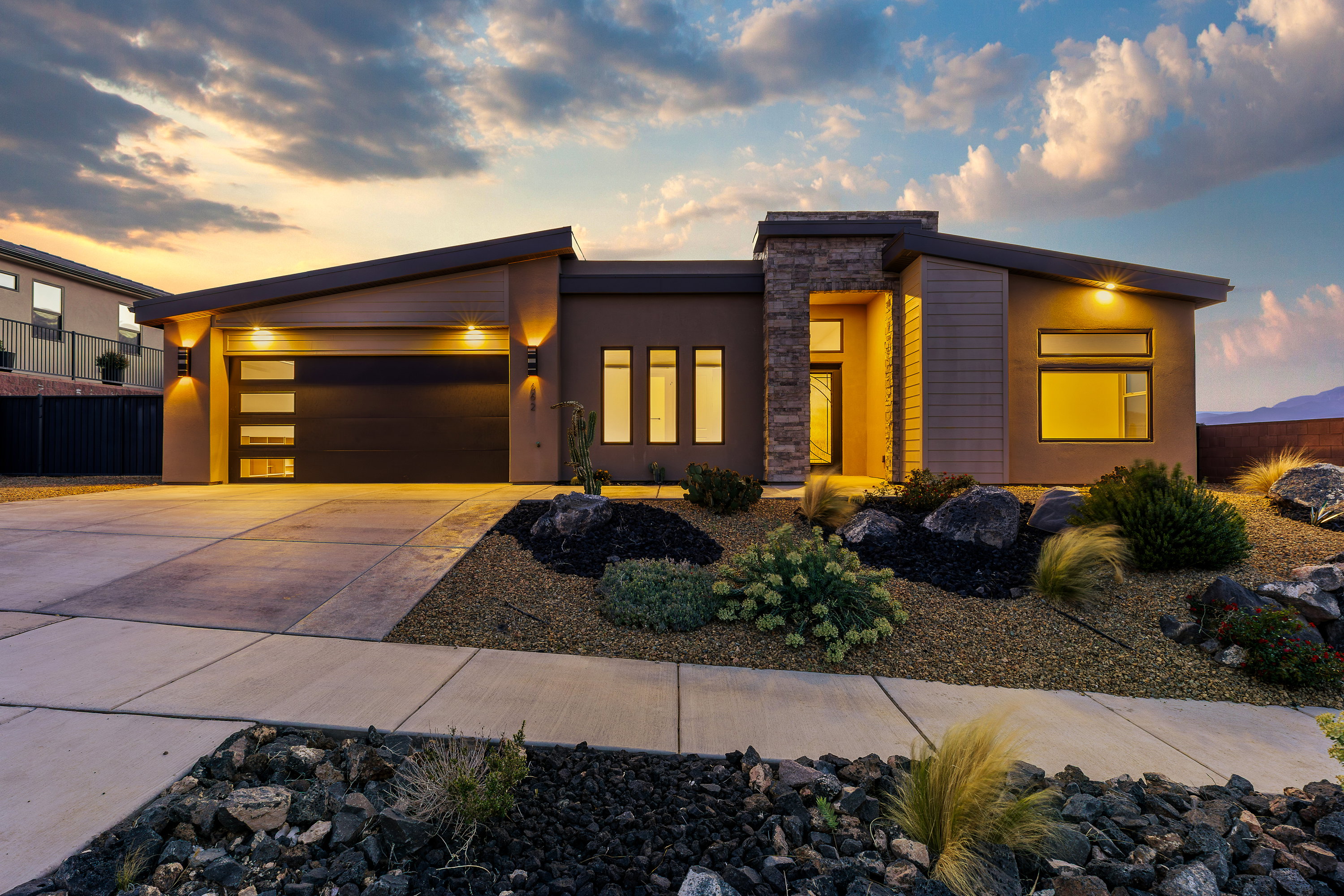 Modern home with a garage, driveway, and stucco siding