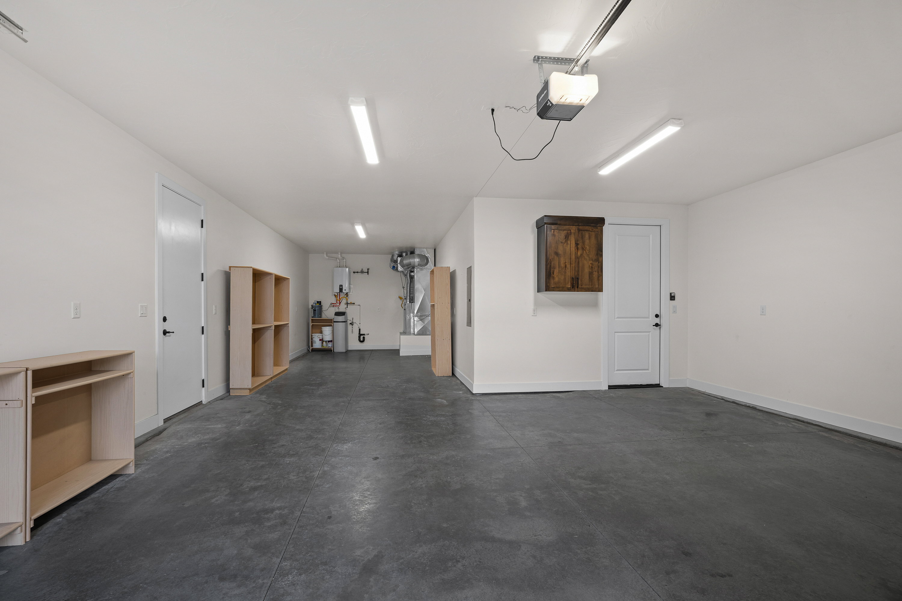 Garage featuring a garage door opener and baseboards