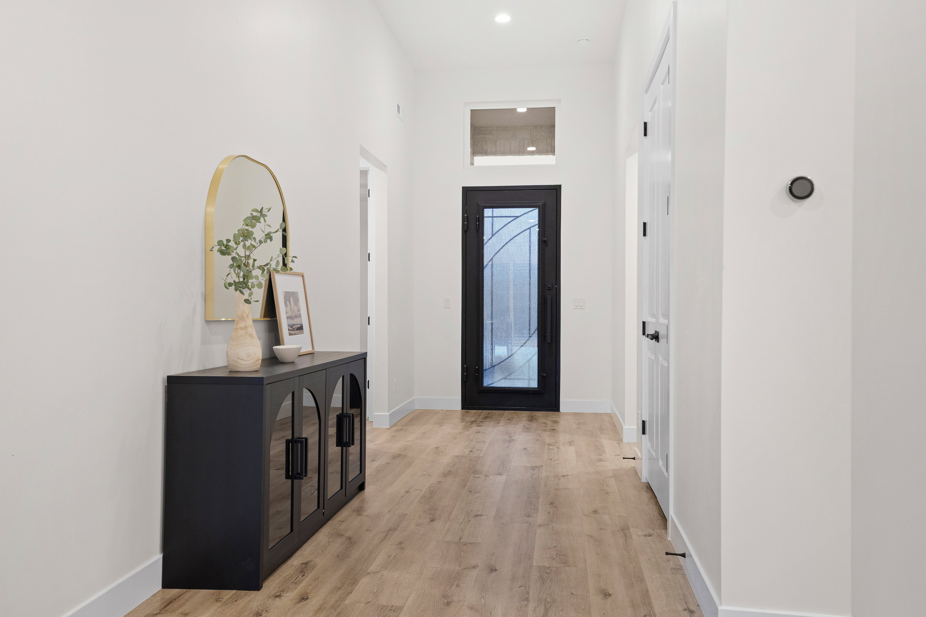 Foyer entrance featuring light wood-type flooring, a high ceiling, and recessed lighting