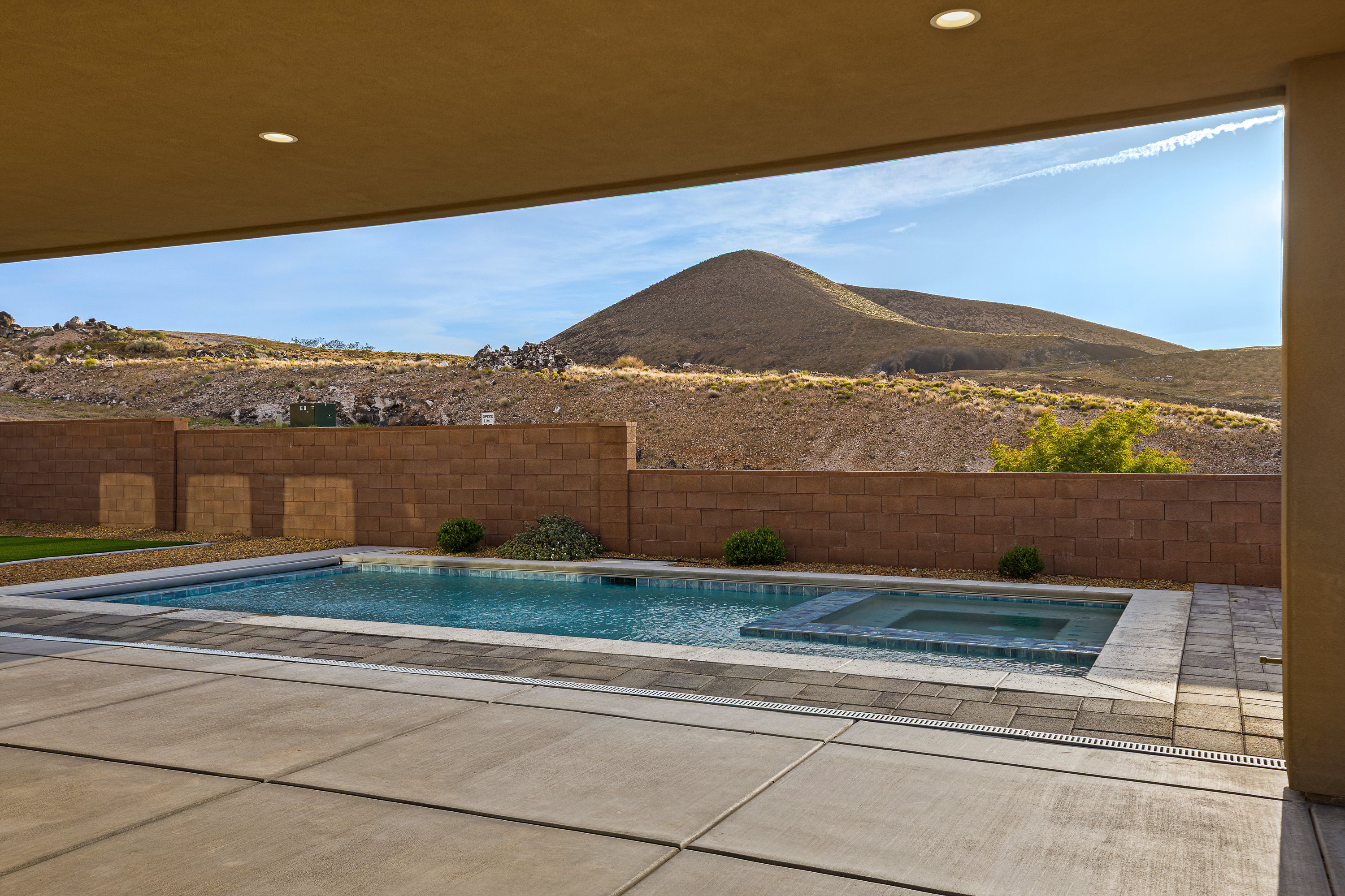 Relaxing pool / spa featuring a mountain view, a fenced backyard, and a patio