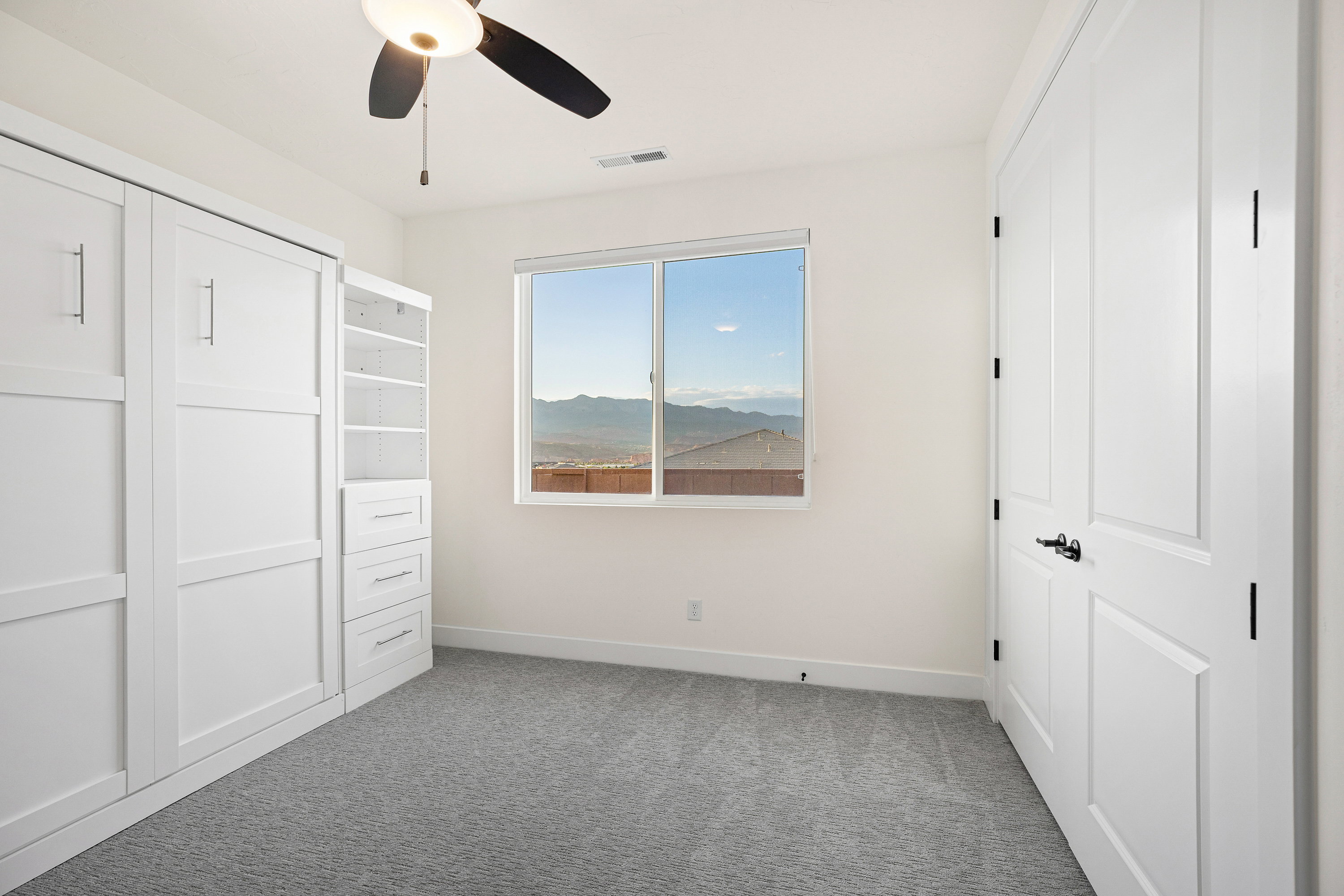 Unfurnished bedroom featuring a closet, light colored carpet, a ceiling fan, and a mountain view