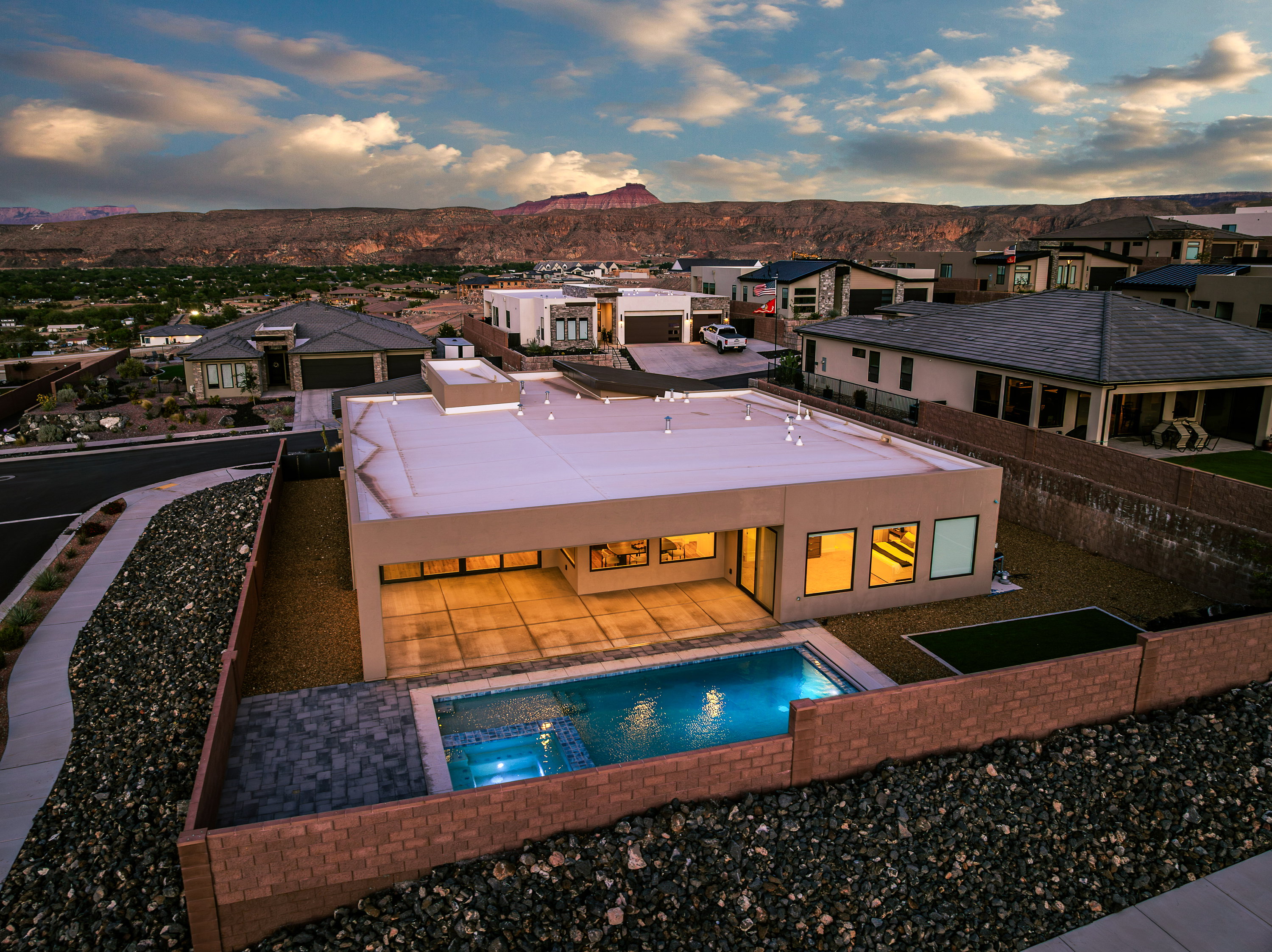 Back of house featuring a residential view, an in-ground hot tub, a patio, a mountain view, and an outdoor pool