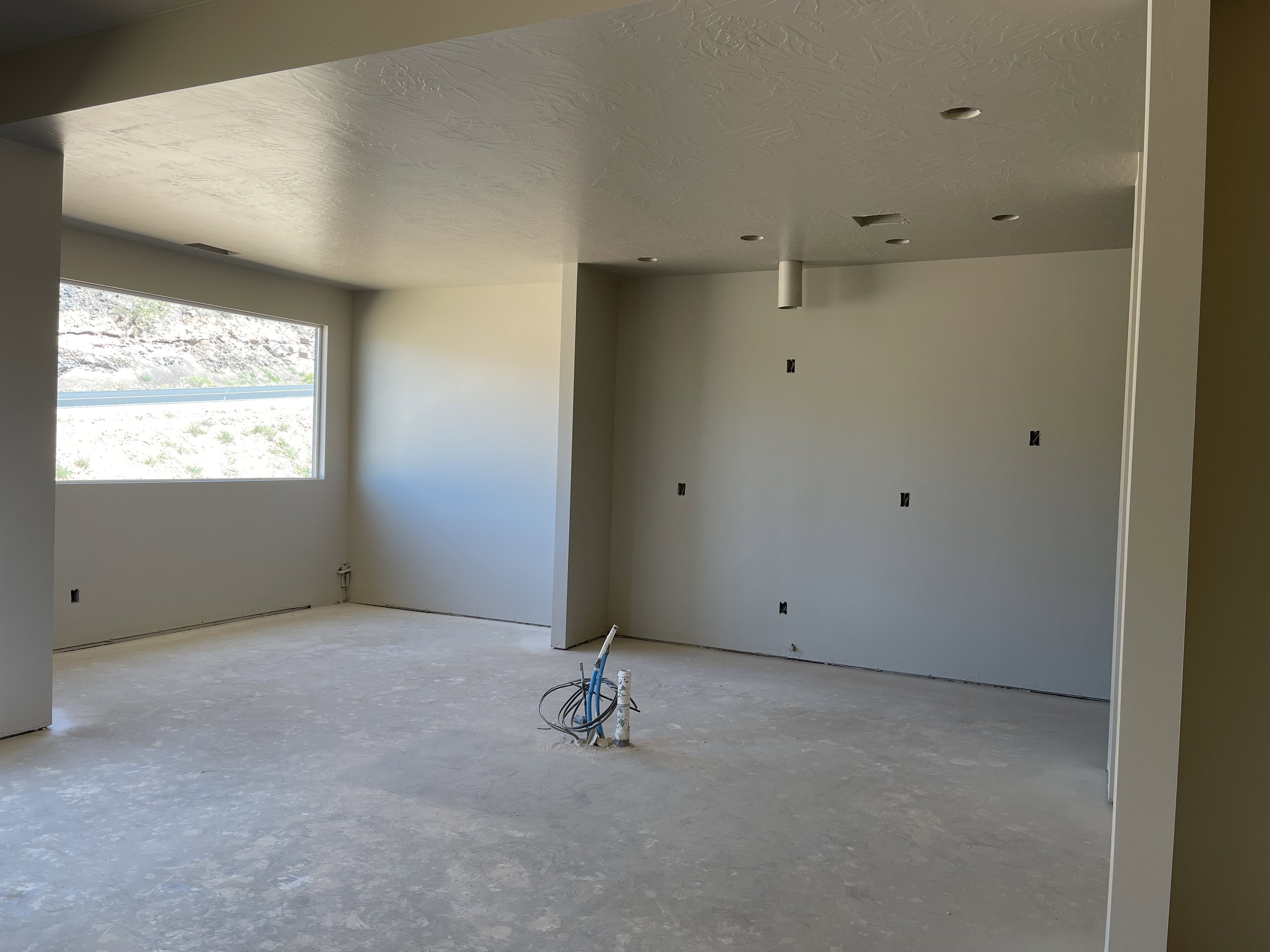 Unfurnished room with unfinished concrete floors and a textured ceiling