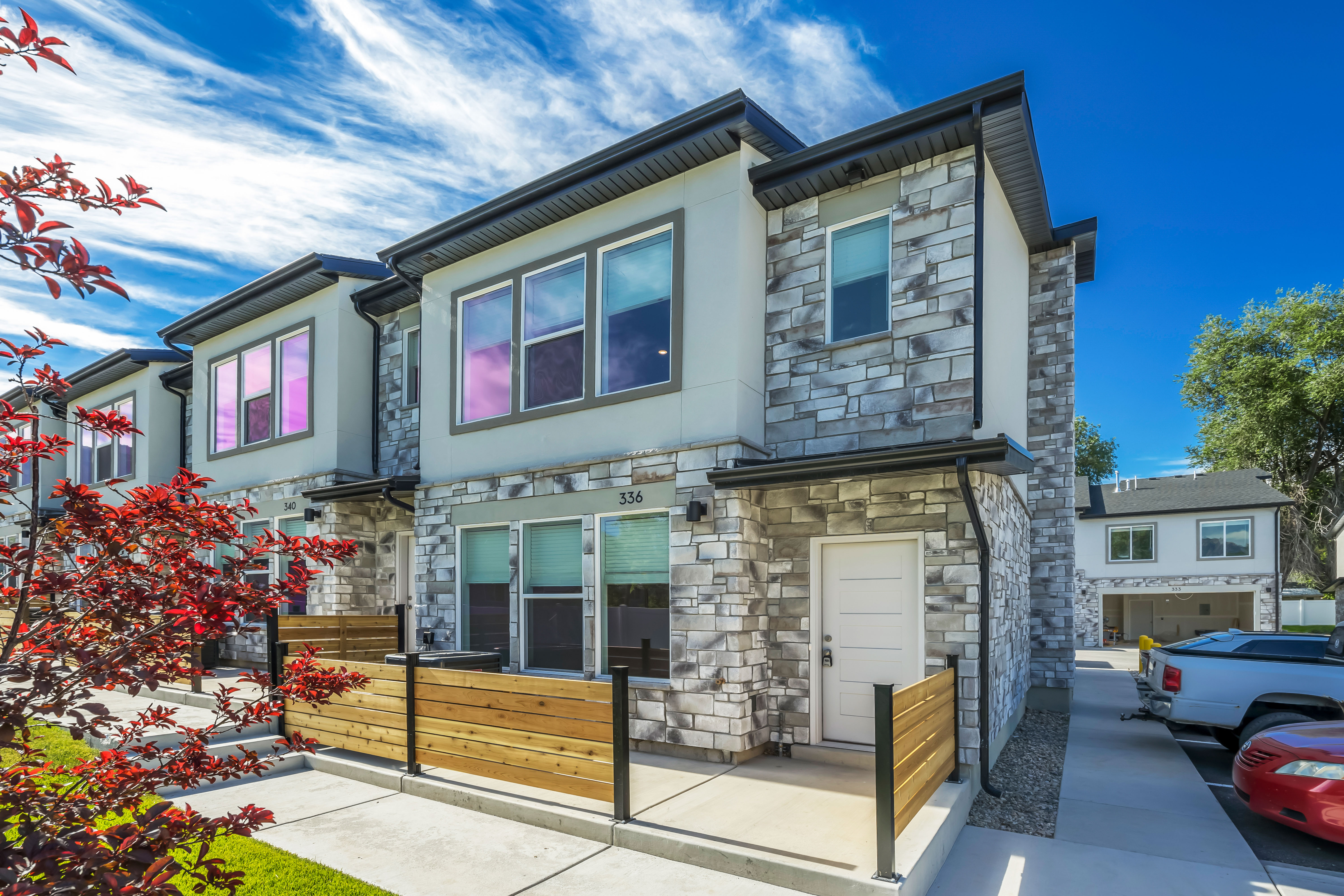 Modern townhome exterior featuring a stacked stone facade and light stucco
