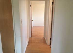 Hall featuring light wood-type flooring and baseboards