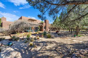 Rear view of property with stucco siding, a chimney, and a patio area