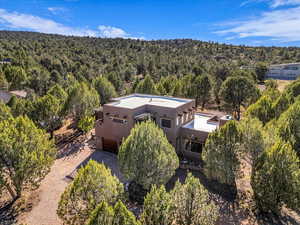 Aerial view of property and surrounding area featuring a heavily wooded area