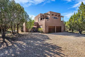View of front of home with stucco siding, a garage, and driveway