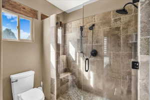 Bathroom featuring toilet and a stall shower