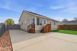 Rear view of property featuring a fenced backyard, a gate, and a patio area