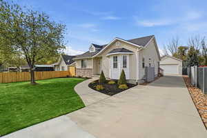 View of front of property featuring a detached garage, an outdoor structure, and roof with shingles