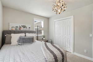 Bedroom with a closet, carpet, and a chandelier