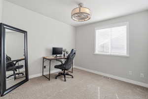 Office space with light colored carpet and baseboards