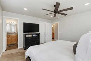 Bedroom featuring connected bathroom, light carpet, ceiling fan, and recessed lighting