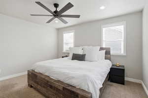 Bedroom with light carpet, ceiling fan, and recessed lighting