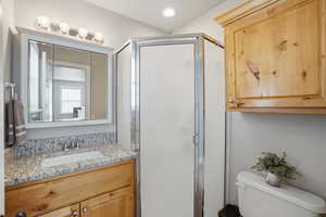 Full bathroom featuring a stall shower, vanity, and recessed lighting